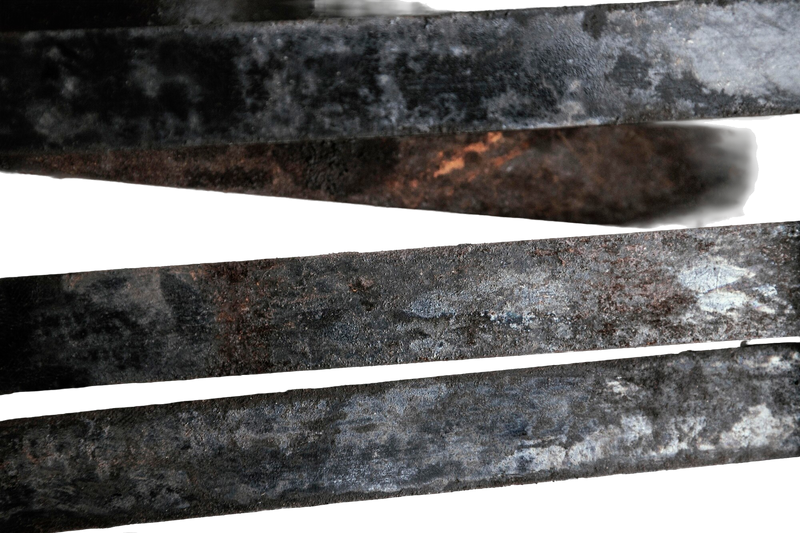 Billets d'acier bruts sur l'enclume avec le feu de la forge rougeoyant en arrière-plan